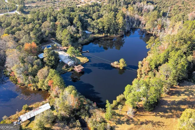 a backyard of a house with large trees and wooden fence