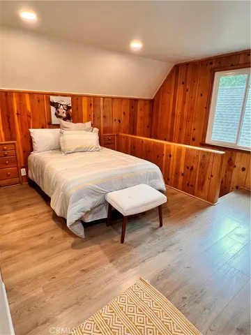 a spacious bedroom with a bed and wooden floor