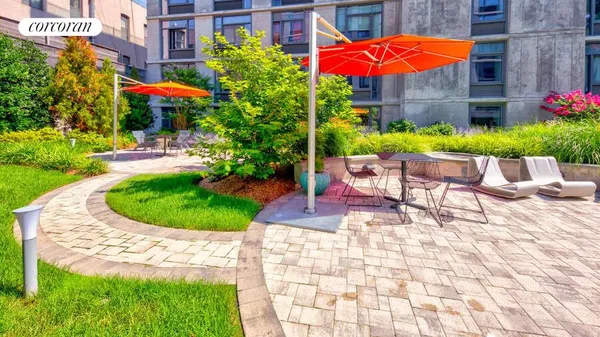 a view of a patio with a table and chairs under an umbrella