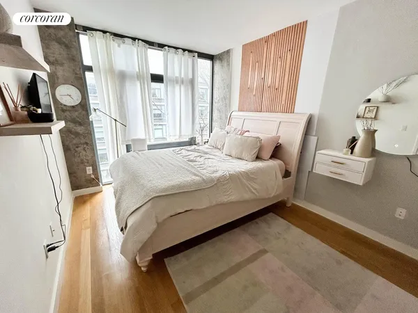 a bedroom with a bed window and a flat screen tv