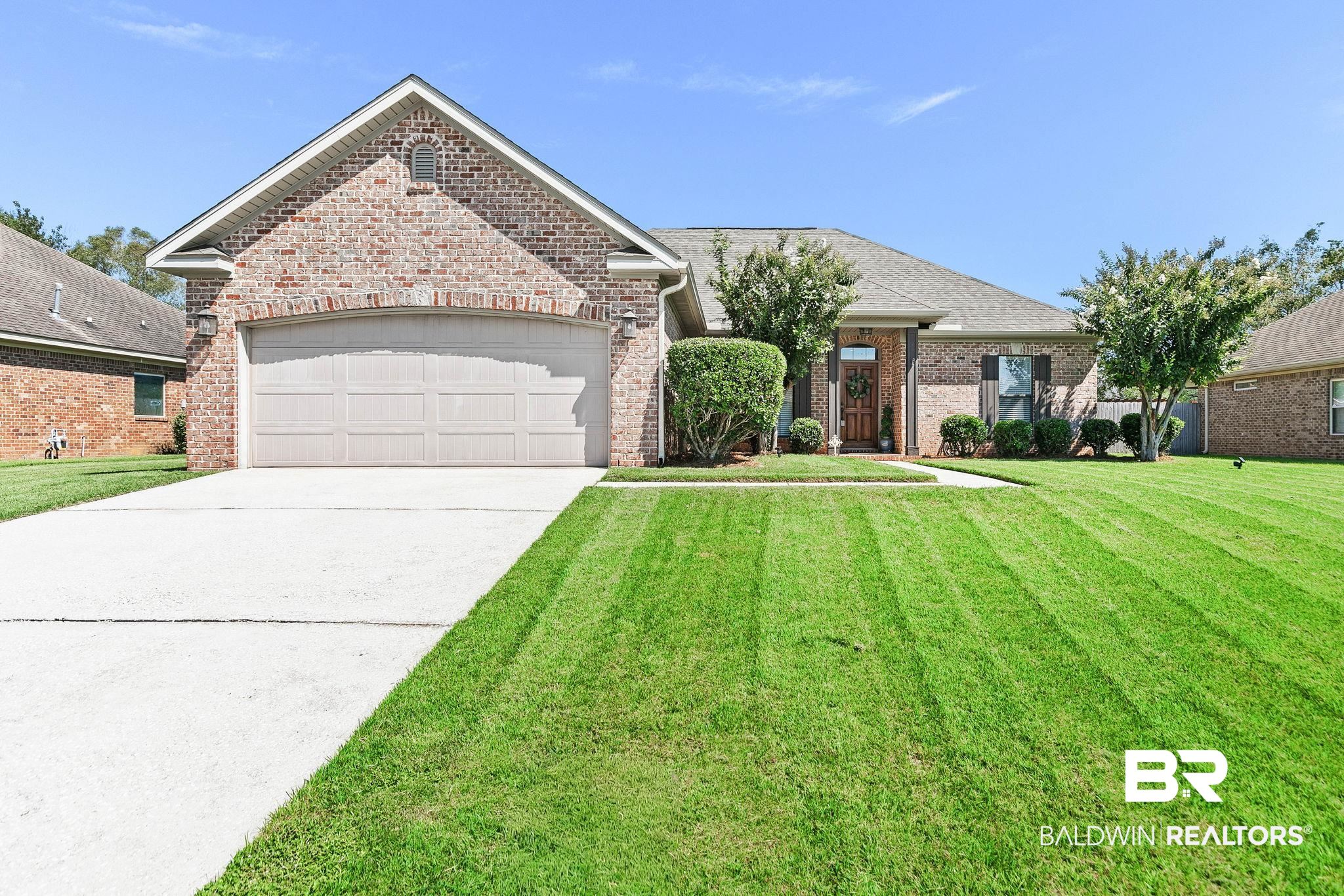 9522 Sanibel Loop Daphne, AL 36526 - Photo 2 of 43 View of front facade with a front lawn, driveway, brick siding, an attached garage, and a shingled roof