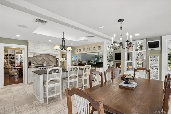 a kitchen with stainless steel appliances kitchen island granite countertop a table and chairs
