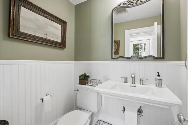 a bathroom with a toilet a sink and mirror