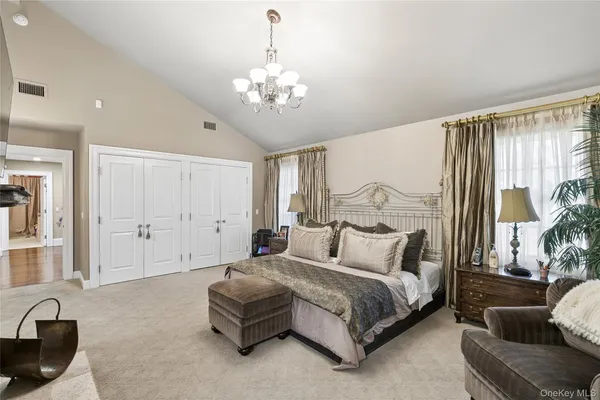 a spacious bedroom with a bed a couch and dresser