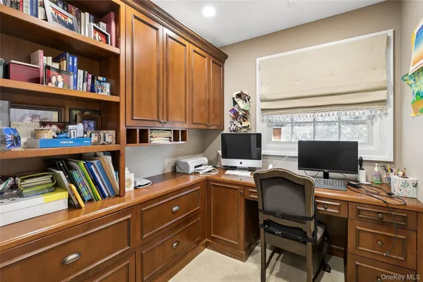 a view of a workspace with furniture and a window