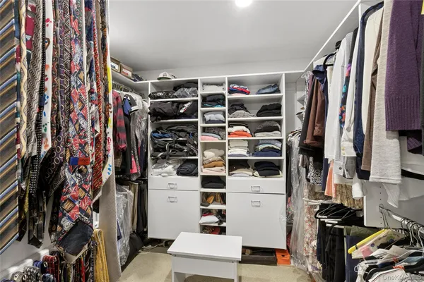 a view of walk in closet with clothes and shoes