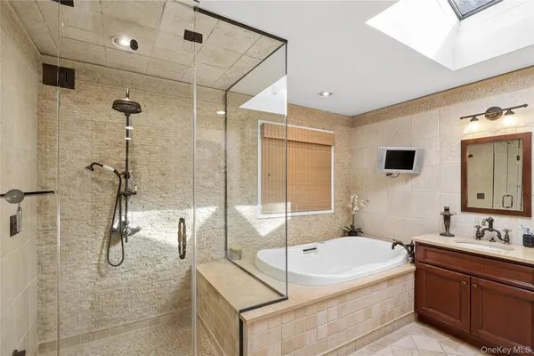 a spacious bathroom with a tub sink shower and mirror