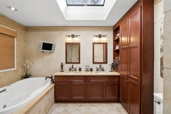 a bathroom with a double vanity sink a mirror and a bathtub