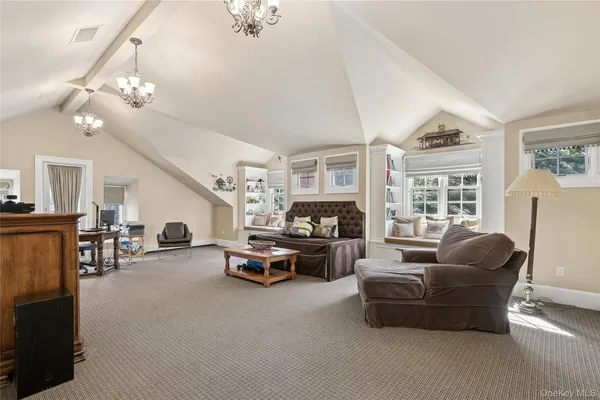 a living room with furniture a chandelier and a flat screen tv