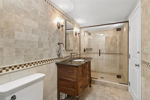 a bathroom with a granite countertop sink a mirror and a shower