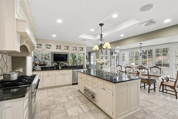 a large kitchen with a large counter top furniture appliances and cabinets