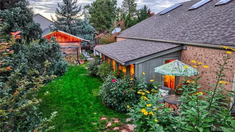 an outdoor space with plants and brick building under an umbrella