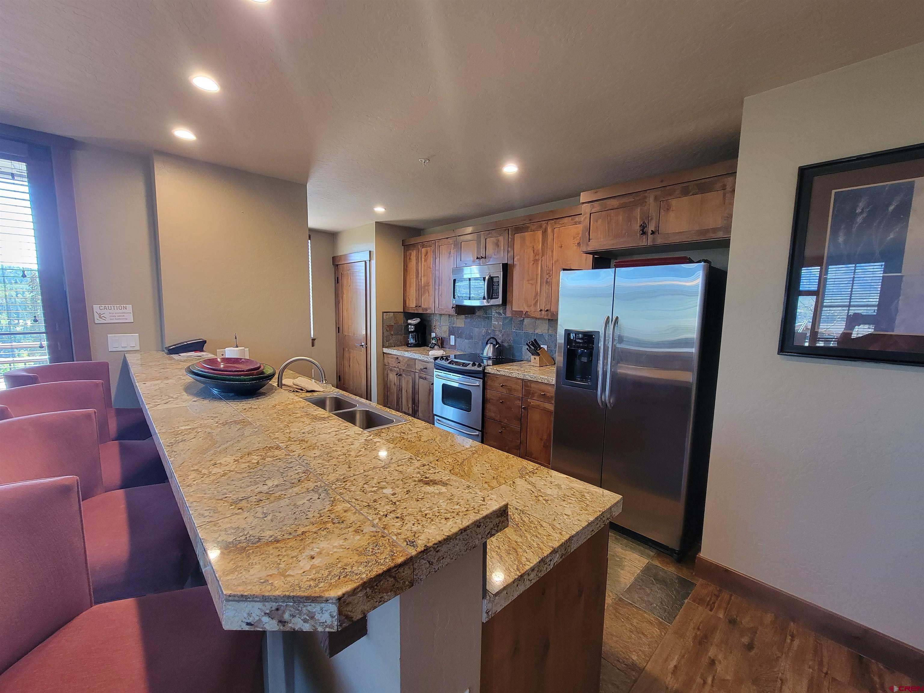 24 Sheol Street, Unit 101D Durango, CO 81301 - Photo 7 of 32 a kitchen with stainless steel appliances granite countertop furniture wooden floor and a window
