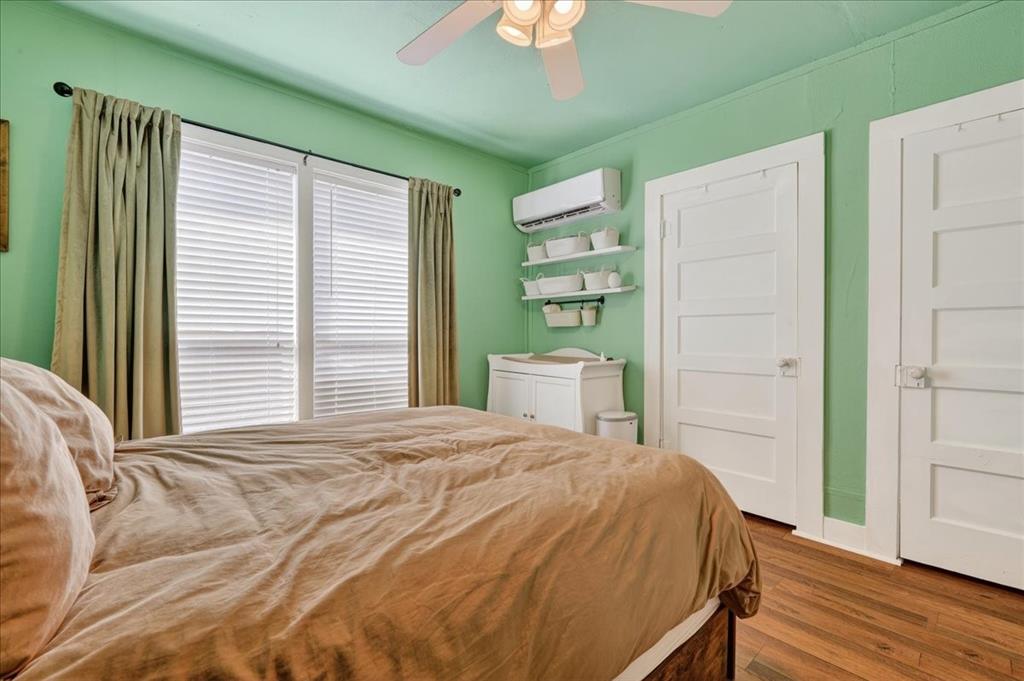 124 West Travis Dublin, TX 76446 - Photo 15 of 30 a bed sitting in a bedroom next to a window and a chandelier