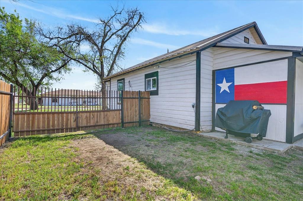 124 West Travis Dublin, TX 76446 - Photo 27 of 30 a view of a house with a small yard and a large tree