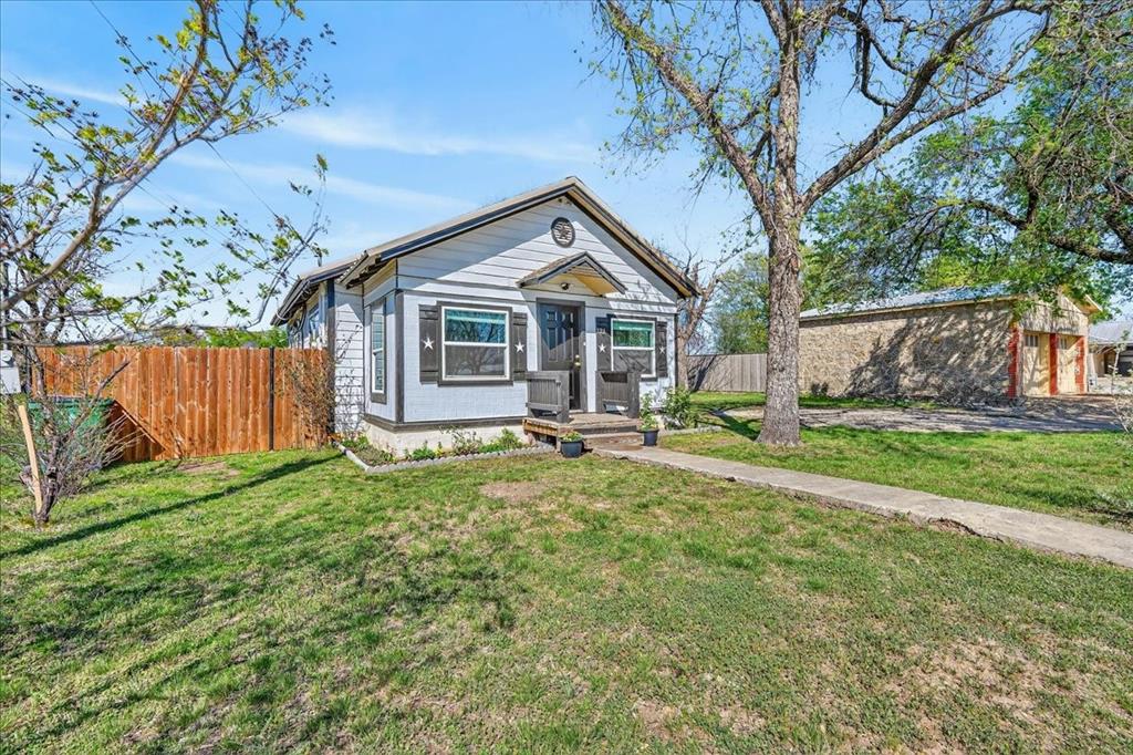 124 West Travis Dublin, TX 76446 - Photo 3 of 30 a view of a house with backyard and a tree