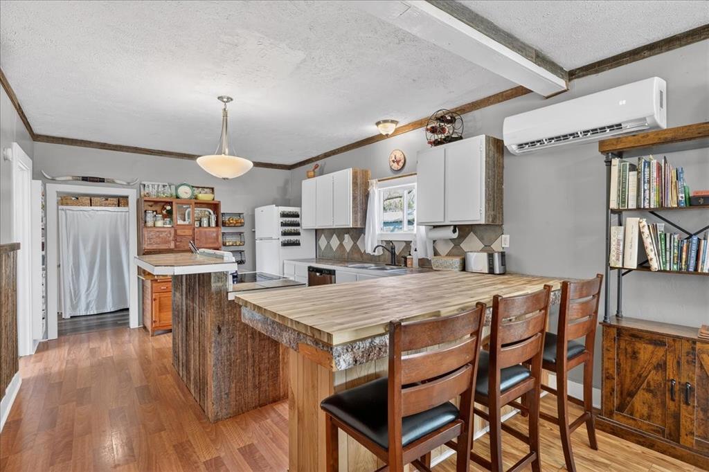 124 West Travis Dublin, TX 76446 - Photo 6 of 30 a kitchen with stainless steel appliances granite countertop a table chairs and a refrigerator