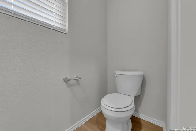 a white toilet sitting next to a white wall
