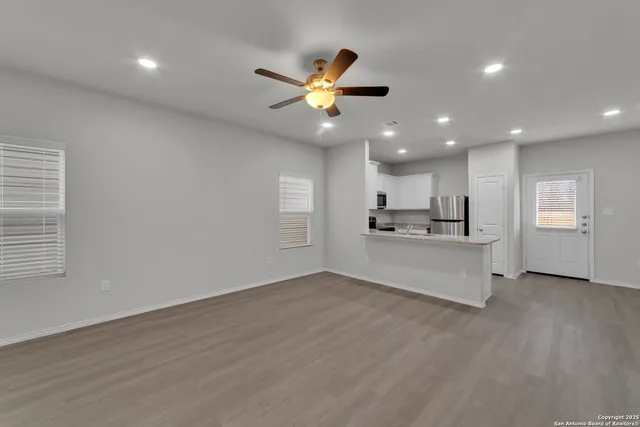 a view of a kitchen with wooden floor and a ceiling fan
