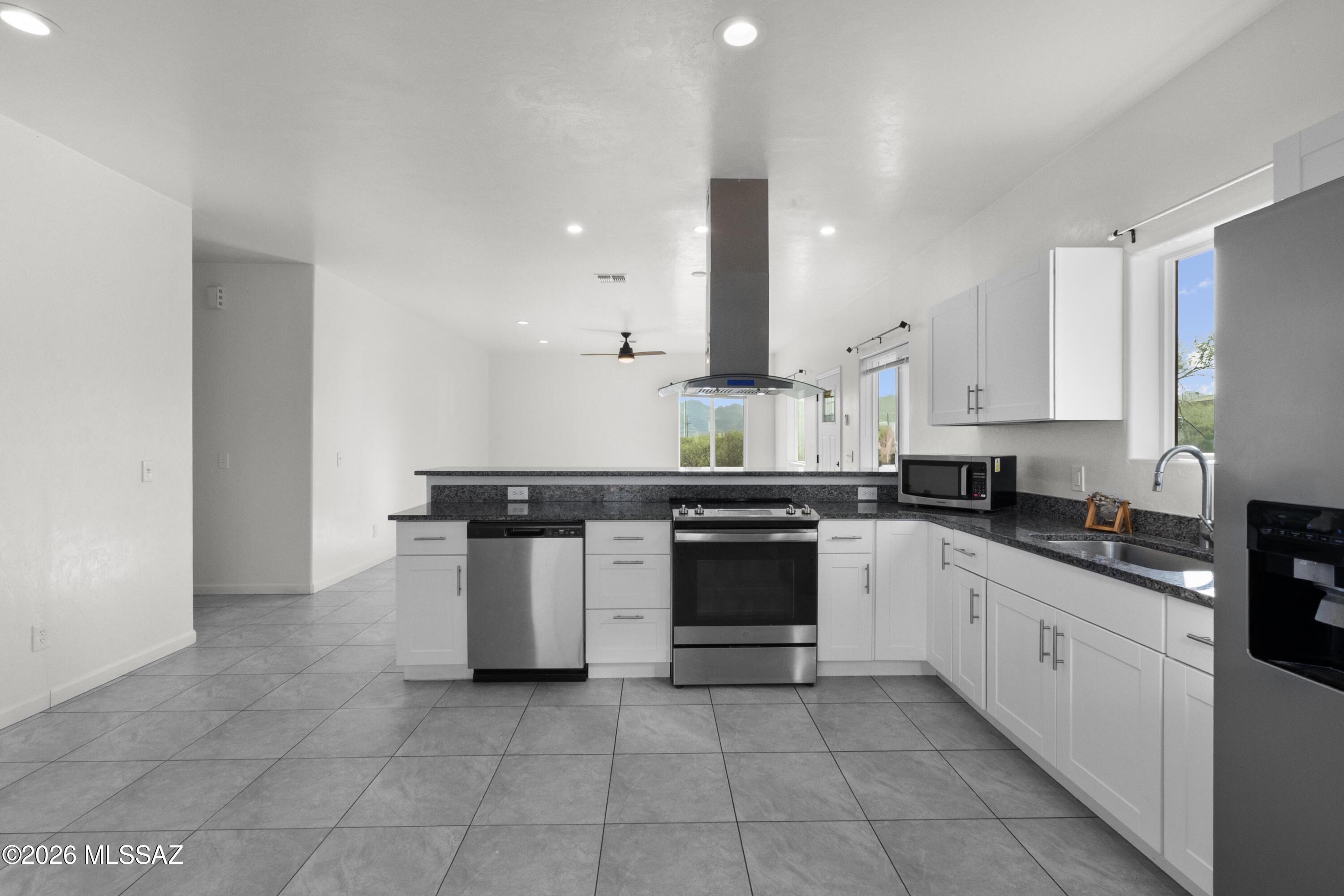 1785 Dove Court Rio Rico, AZ 85648 - Photo 12 of 31 a kitchen with stainless steel appliances a sink stove and cabinets