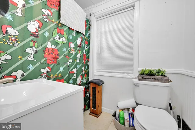 a bathroom with a sink a toilet and a shower curtain