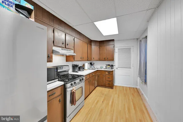 a kitchen with stainless steel appliances granite countertop a stove a sink and a refrigerator