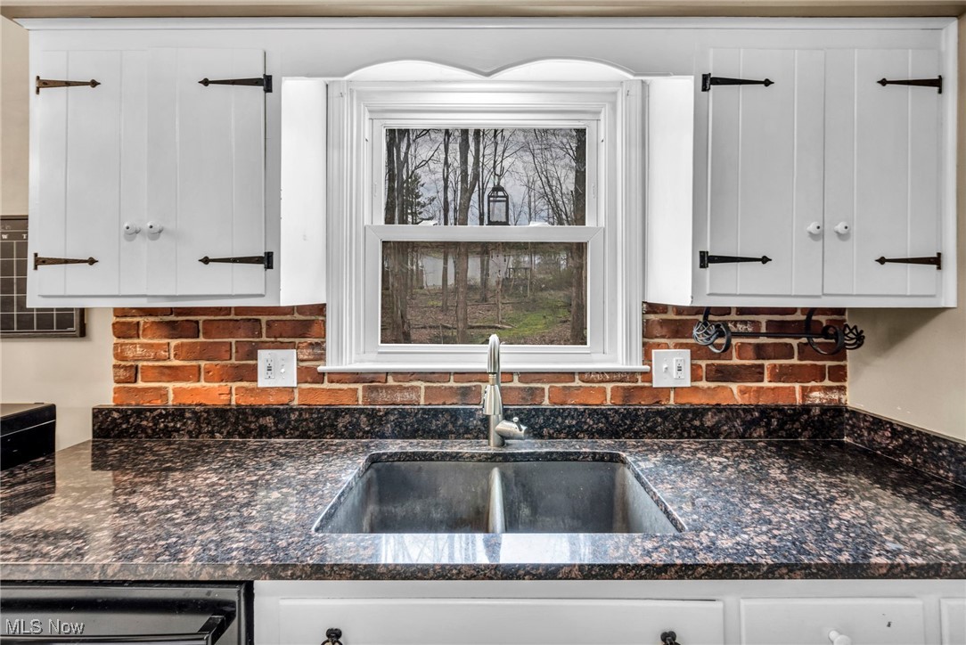 12150 Heath Road Chesterland, OH 44026 - Photo 10 of 43 Kitchen with dark stone counters, decorative backsplash, white cabinets, a sink, and dishwasher