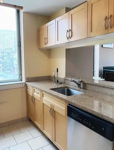 a kitchen with granite countertop cabinets stainless steel appliances and a window