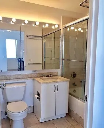 a bathroom with a granite countertop sink a toilet and shower