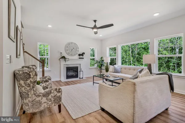 a living room with furniture a fireplace and a large window