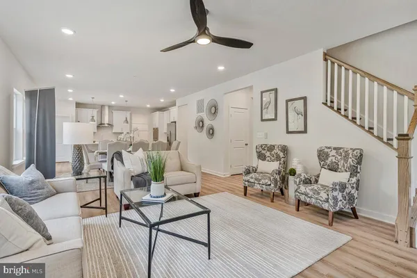 a living room with furniture kitchen view and a chandelier