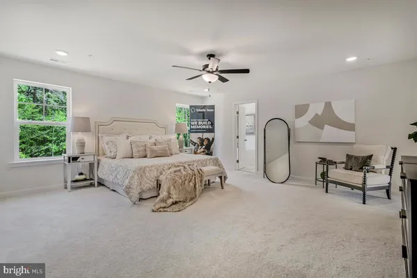 a bedroom with a bed a chandelier and a large window