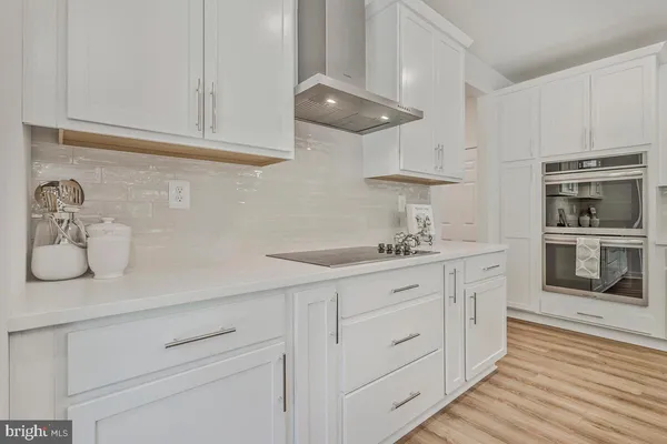 a kitchen with stainless steel appliances granite countertop a sink a stove and cabinets