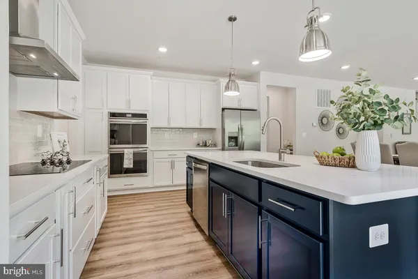 a kitchen with kitchen island a sink appliances and cabinets