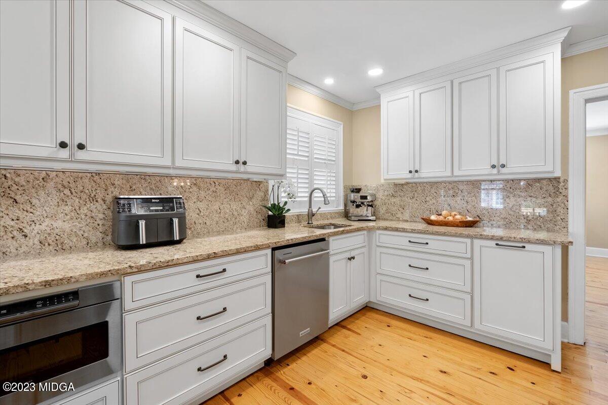 394 Overlook Road Macon, GA 31204 - Photo 3 of 29 a kitchen with granite countertop white cabinets and white appliances