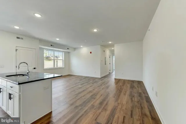 a view of a kitchen with a sink and wooden floor