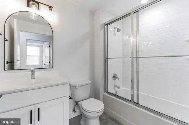 a bathroom with a toilet a sink and a mirror