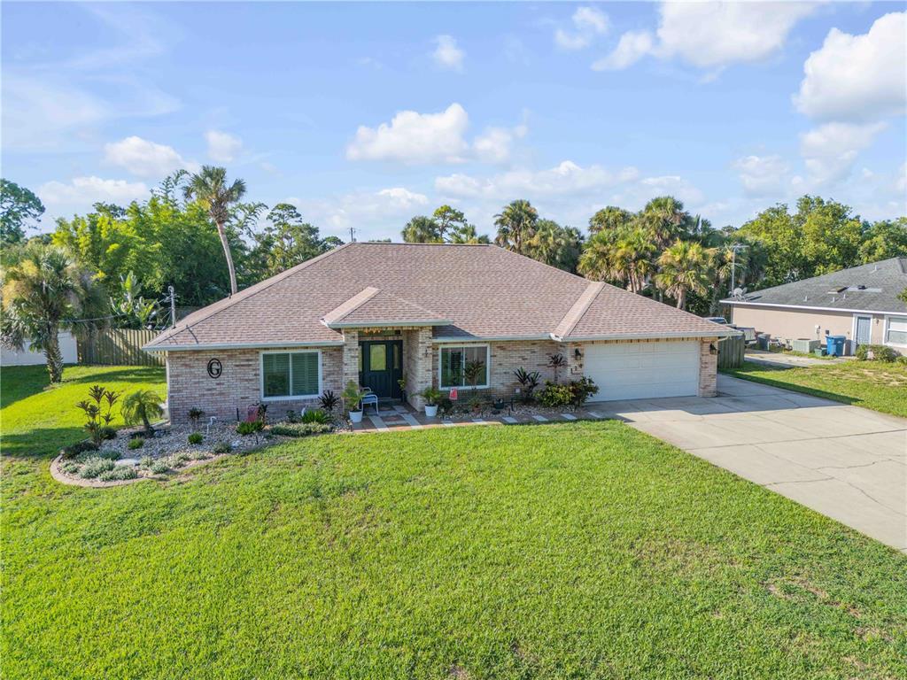 a view of a house with table and chairs under an umbrella