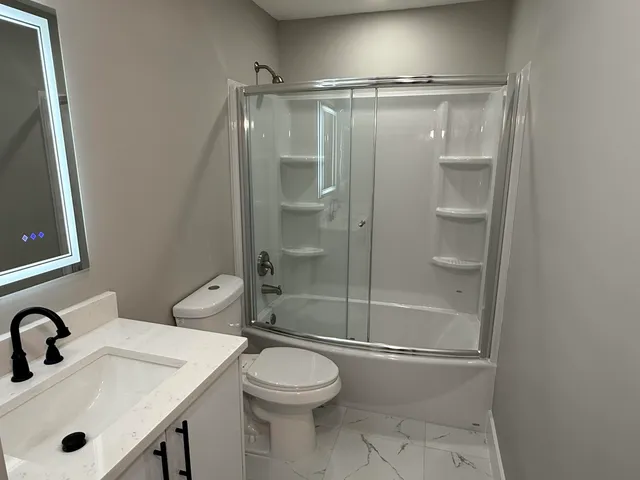 a bathroom with a sink mirror vanity and toilet
