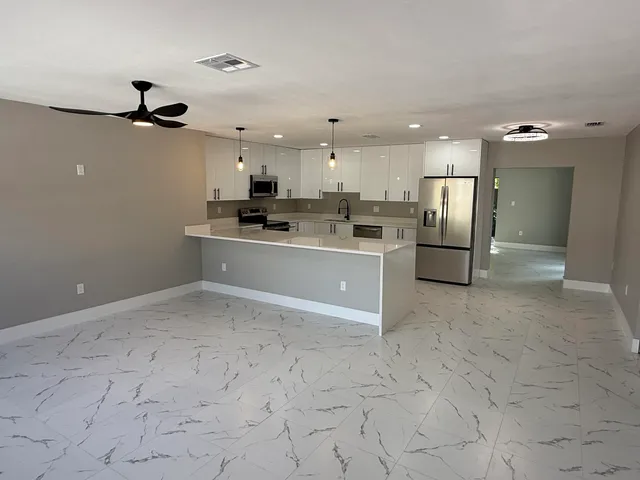 a view of a kitchen with a sink and stainless steel appliances