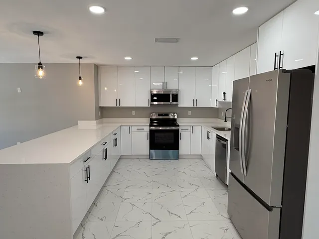 a kitchen with white cabinets and stainless steel appliances