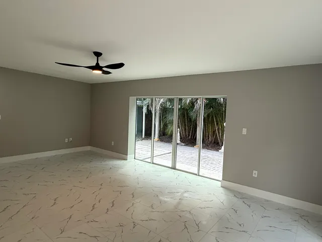 a view of a livingroom with a ceiling fan and window