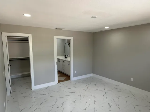 an empty room with closet and mirror