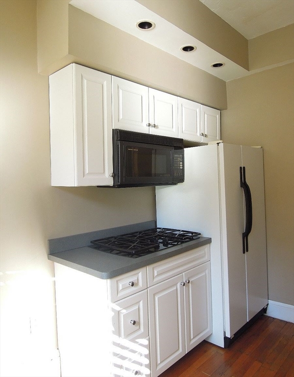 8 Garrison Street, Unit 209 Boston, MA 02116 - Photo 25 of 33 a kitchen with stainless steel appliances a refrigerator a stove a microwave and cabinets