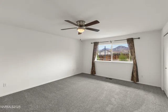 a view of a room with air conditioner and a ceiling fan