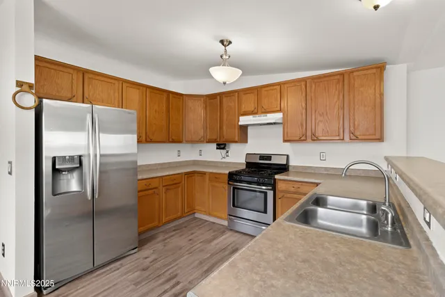 a kitchen with stainless steel appliances granite countertop a refrigerator stove top oven and sink