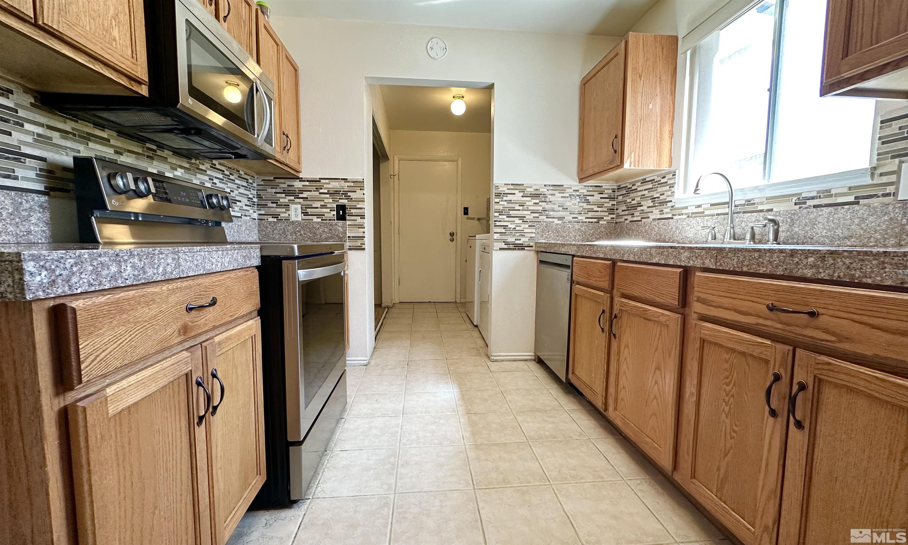 3320 Downey Avenue Reno, NV 89503 - Photo 6 of 20 a kitchen with stainless steel appliances granite countertop a sink and wooden cabinets