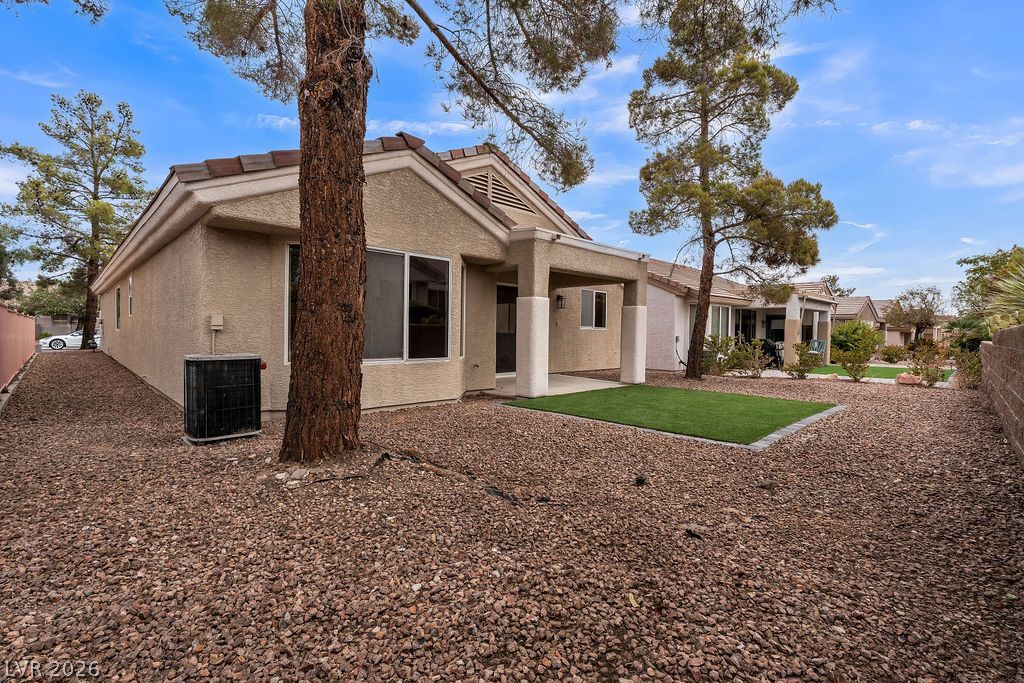 2139 Chapman Ranch Drive Henderson, NV 89012 - Photo 24 of 58 A neatly maintained backyard features a small patch of artificial turf surrounded by decorative gravel.