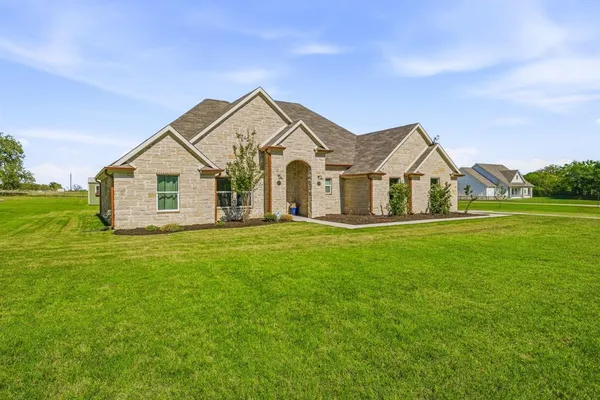 a view of a house with a big yard potted plants and large tree