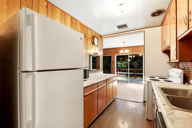 a kitchen with a refrigerator a sink and a stove top oven